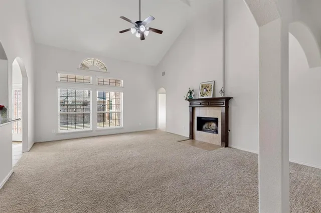 a view of an empty room with a fireplace and a window