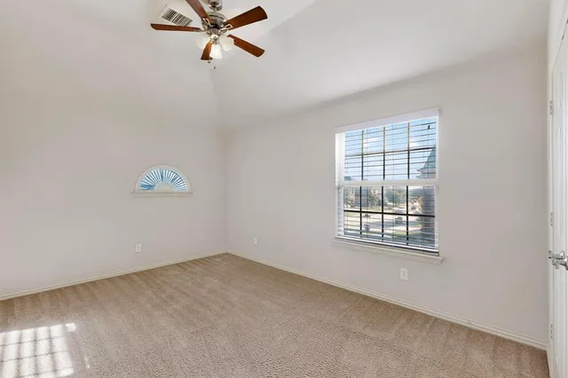 an empty room with windows and fan