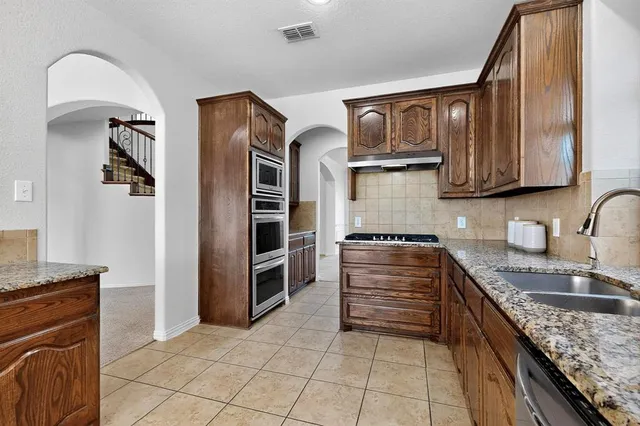 a kitchen with stainless steel appliances granite countertop a stove and a sink