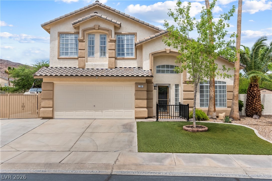 708 Vortex Avenue Henderson, NV 89002 - Photo 4 of 71 A cream-colored residence offers inviting curb appeal, featuring a two-car garage and manicured front lawn.