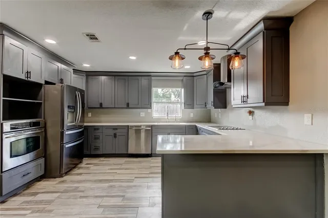 a kitchen with granite countertop a sink appliances and cabinets
