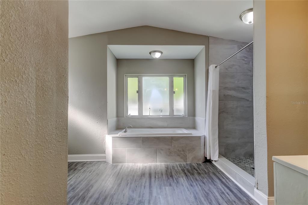 8330 Lafitte Drive Hudson, FL 34667 - Photo 26 of 34 a view of a hallway with wooden floor and a bathroom