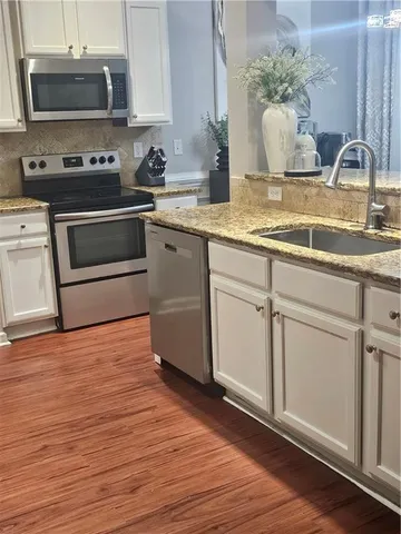 a kitchen with stainless steel appliances granite countertop a sink a stove and a microwave