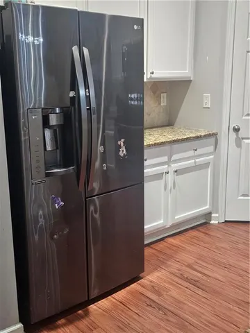 a view of a refrigerator in kitchen and wooden floor