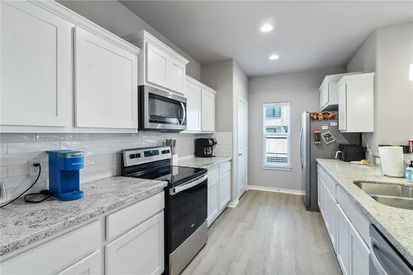 a large kitchen with kitchen island a large counter space a sink stainless steel appliances and cabinets