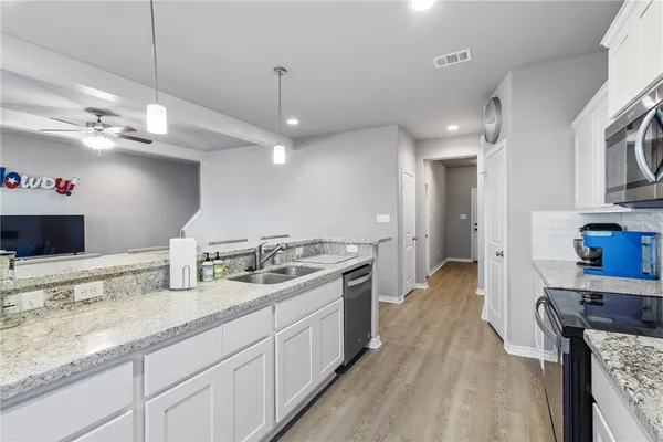 a kitchen with a dining table chairs wooden cabinets and white stainless steel appliances