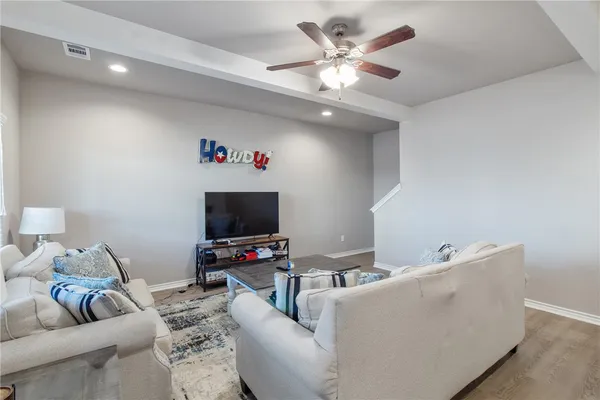a living room with furniture and a view of kitchen
