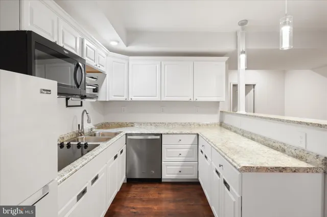 a kitchen with granite countertop a sink a stove and cabinets