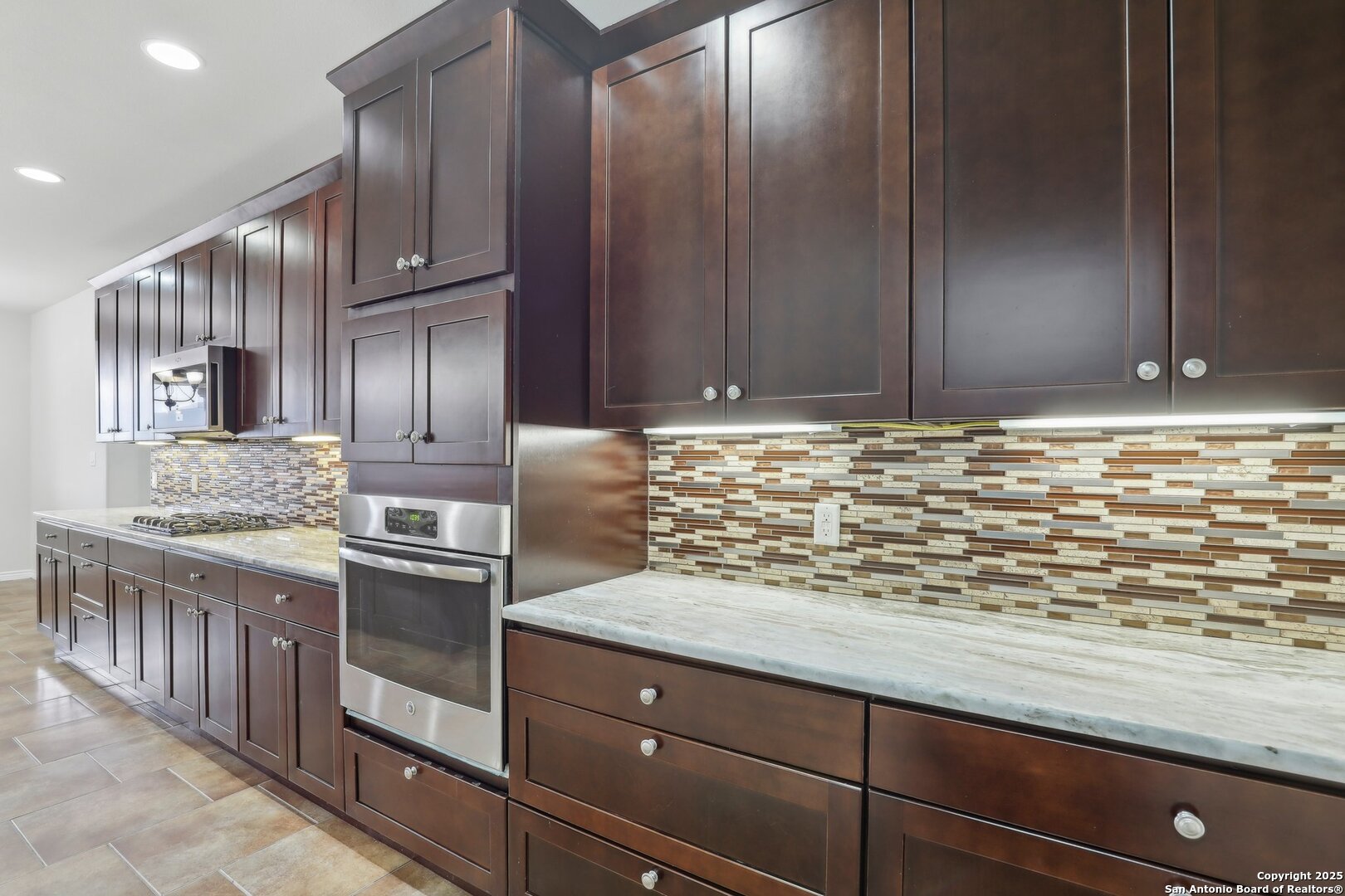 138 Gable Street Kyle, TX 78640 - Photo 14 of 51 a kitchen with granite countertop stainless steel appliances wooden cabinets a sink and a counter top space
