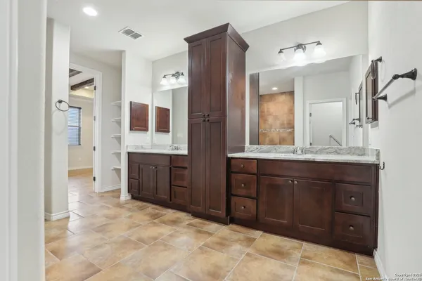 a spacious bathroom with a granite countertop sink mirror and a