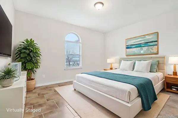 a spacious bedroom with a bed and a potted plant