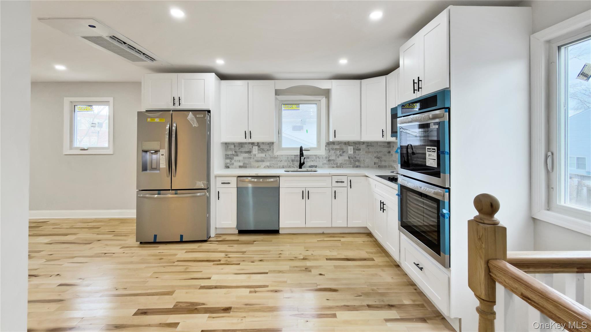 37 Deal Road Island Park, NY 11558 - Photo 20 of 50 Kitchen with plenty of natural light, stainless steel appliances, white cabinets, and recessed lighting