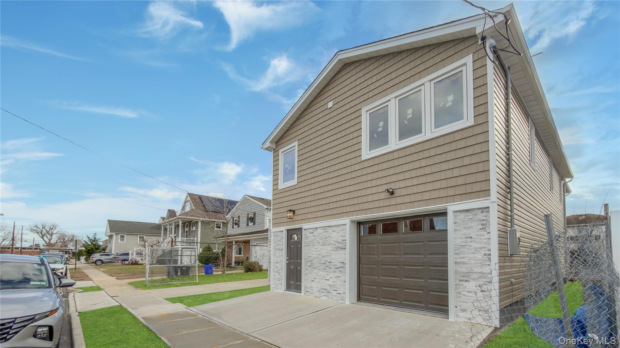 37 Deal Road Island Park, NY 11558 - Photo 2 of 50 View of side of home featuring a garage and brick siding