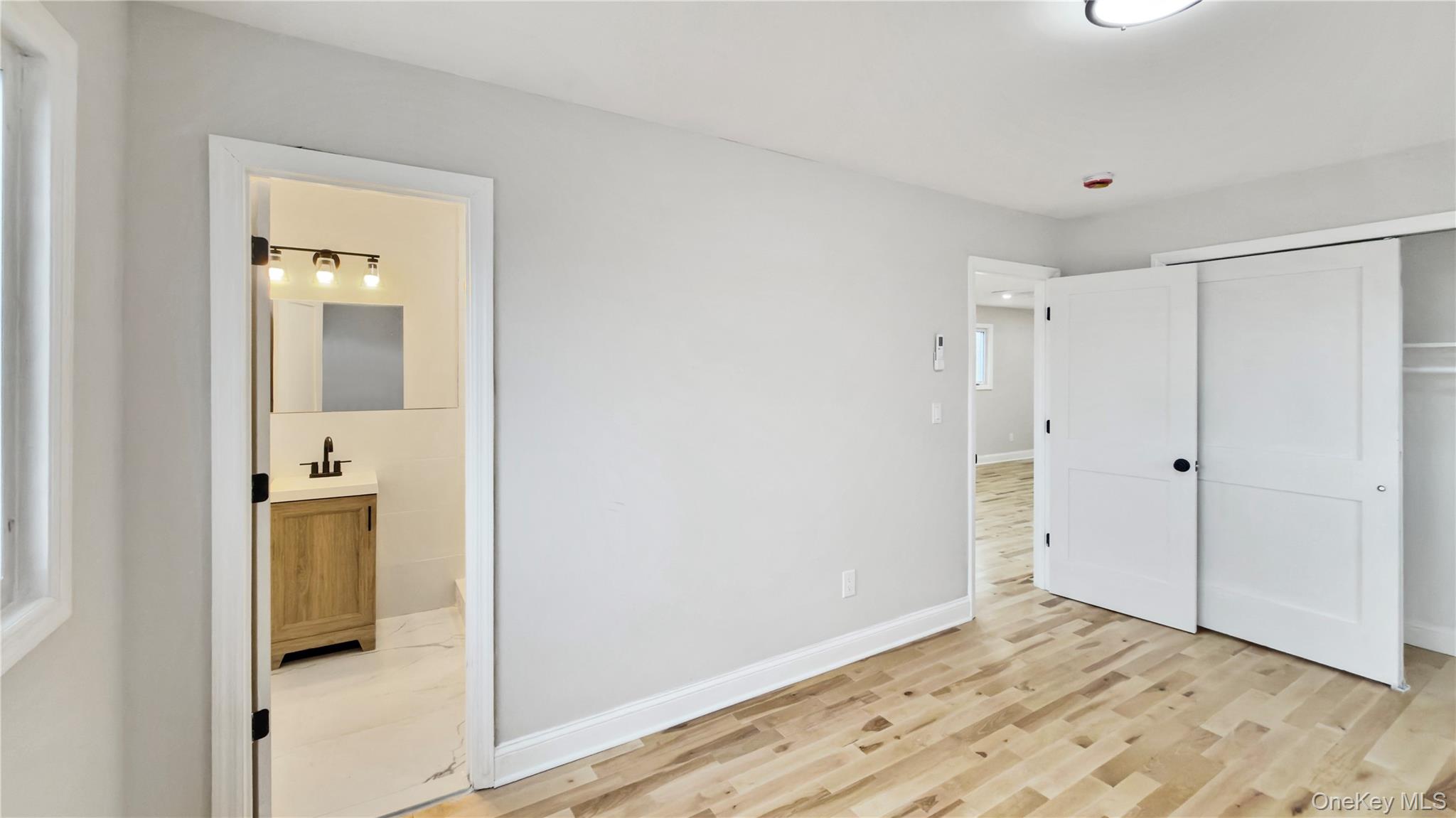 37 Deal Road Island Park, NY 11558 - Photo 27 of 50 Unfurnished bedroom featuring a closet, ensuite bathroom, and light wood finished floors
