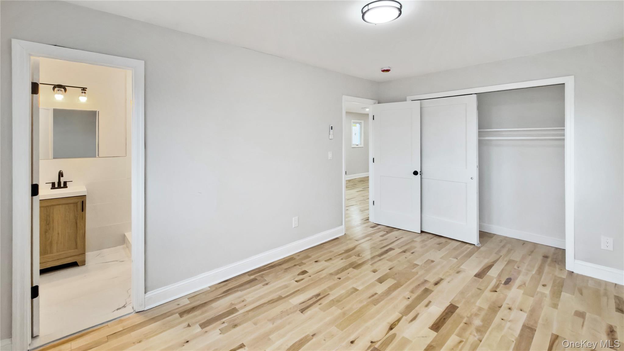 37 Deal Road Island Park, NY 11558 - Photo 31 of 50 Unfurnished bedroom featuring light wood-style floors, a closet, and ensuite bathroom