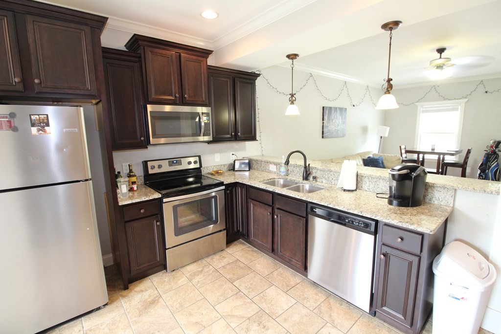 1348 Weeks Drive Northeast Cleveland, TN 37312 - Photo 7 of 25 a kitchen with granite countertop kitchen island stainless steel appliances a refrigerator a sink a stove a microwave and cabinets