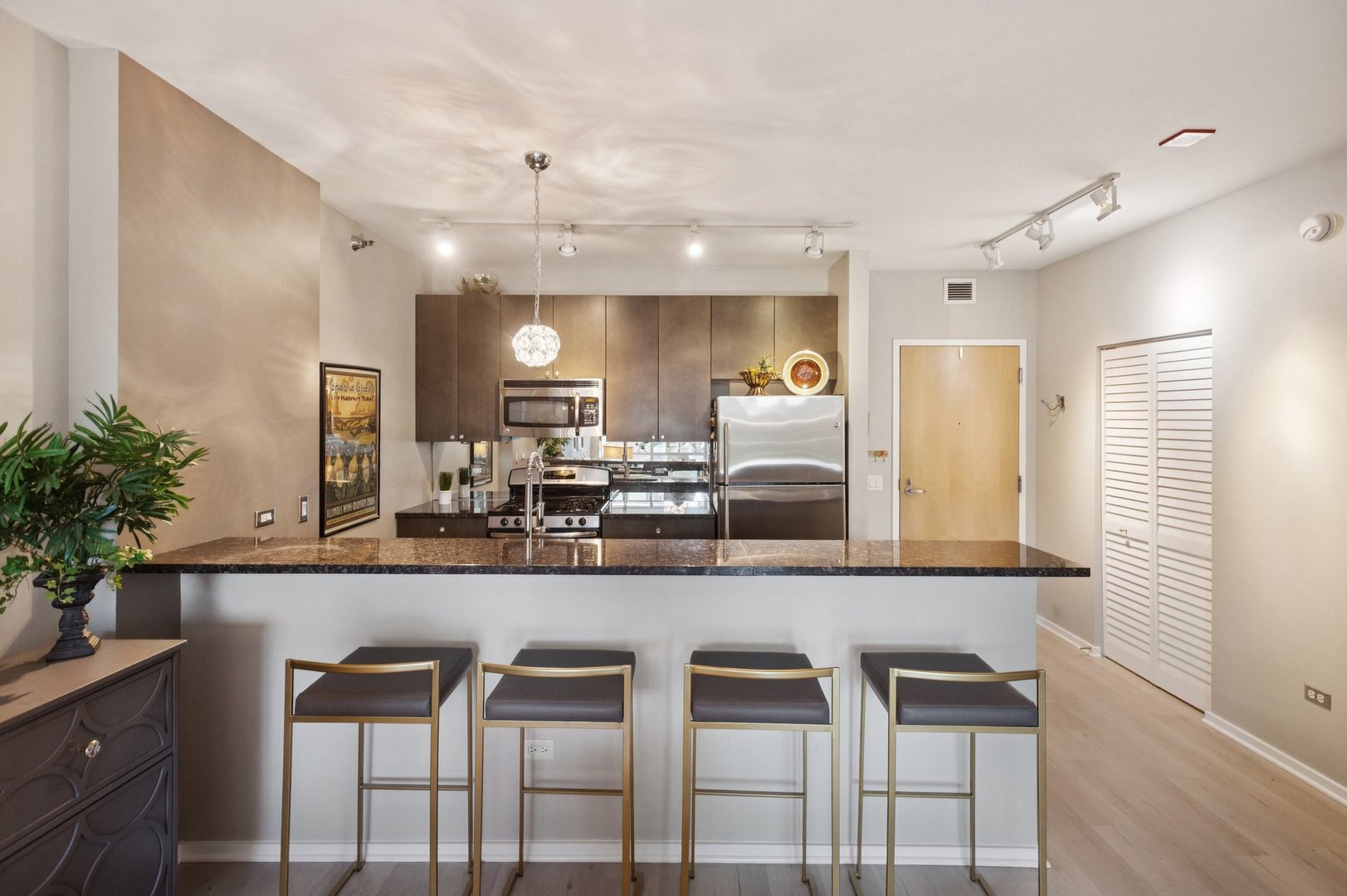 123 South Green Street, Unit 409B Chicago, IL 60607 - Photo 7 of 16 a kitchen with kitchen island granite countertop a sink and chairs