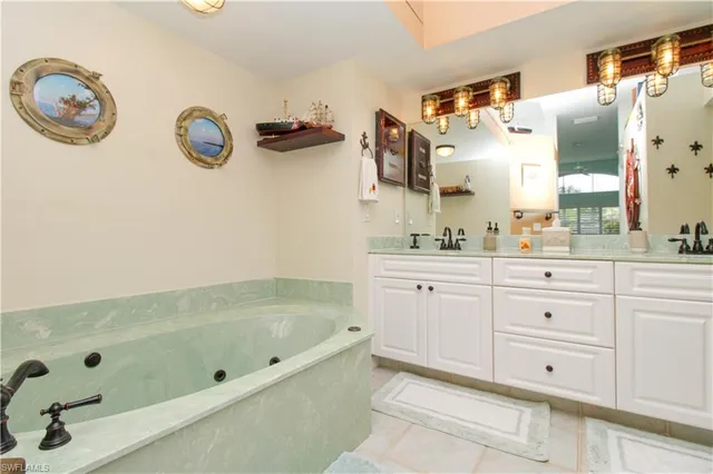 a bathroom with a tub sink and mirror