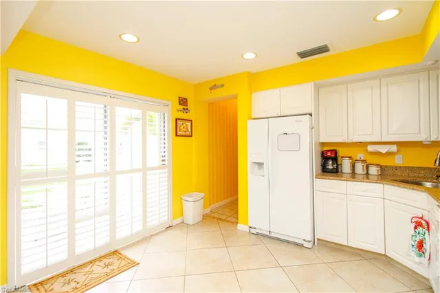 a large white kitchen with a sink a stove top oven and white cabinets