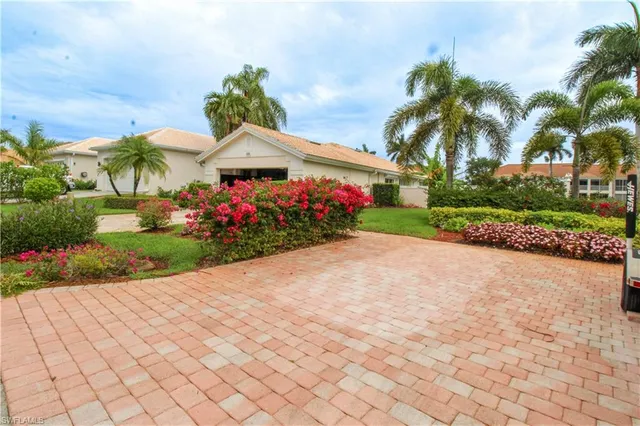 a front view of a house with a yard and potted plants