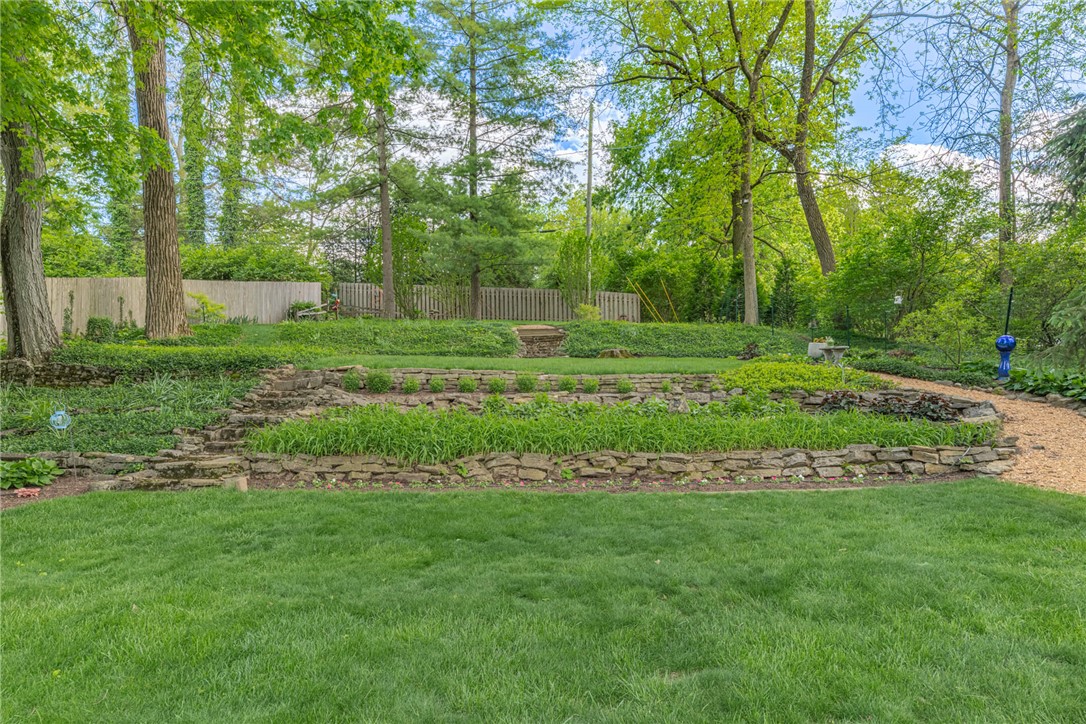 156 West Hadley Road Dayton, OH 45419 - Photo 51 of 71 This lush backyard features tiered landscaping, a natural path, and mature trees, creating a serene outdoor oasis.
