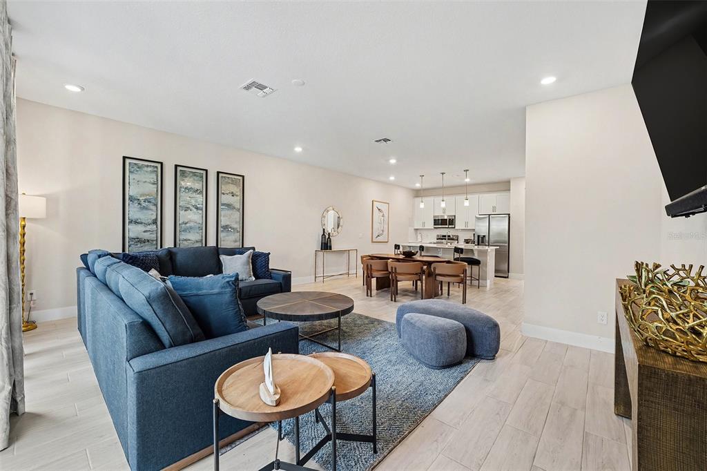 7841 Spectrum Drive Reunion, FL 34747 - Photo 3 of 30 a living room with furniture a flat screen tv and kitchen view
