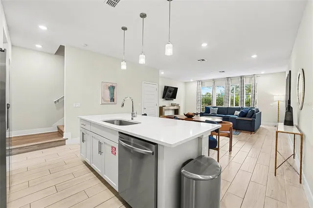 a large kitchen with a counter space a sink stainless steel appliances and cabinets