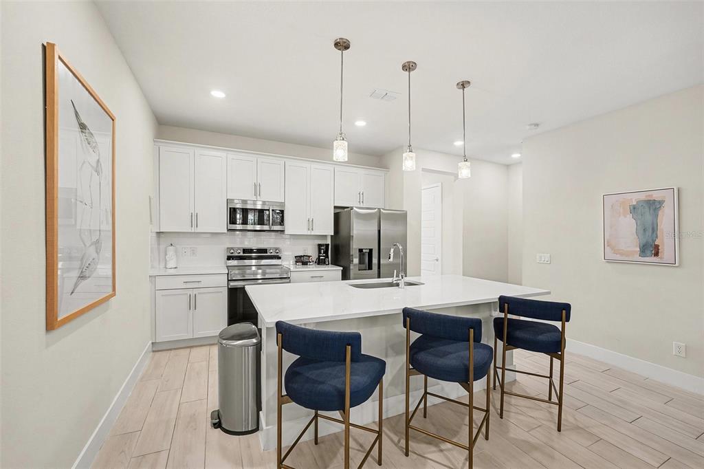 7841 Spectrum Drive Reunion, FL 34747 - Photo 10 of 30 a kitchen with kitchen island wooden cabinets and refrigerator