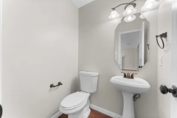a bathroom with a toilet a sink and mirror