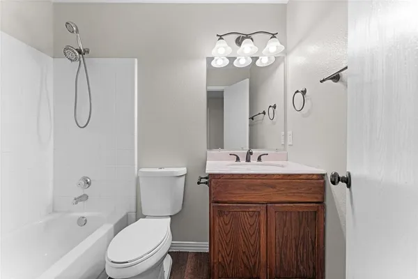 a bathroom with a granite countertop sink a toilet and shower