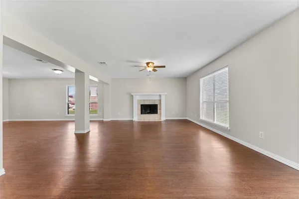 a view of a livingroom with wooden floor and a fireplace
