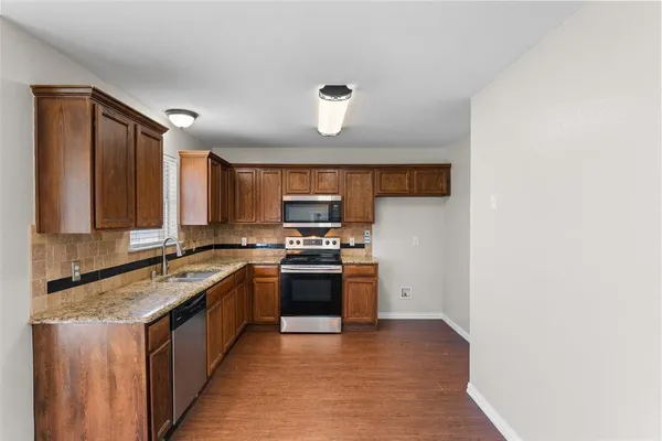 a kitchen with stainless steel appliances granite countertop a stove a sink and a refrigerator