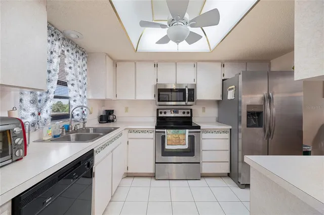 a kitchen with a sink stainless steel appliances and white cabinets