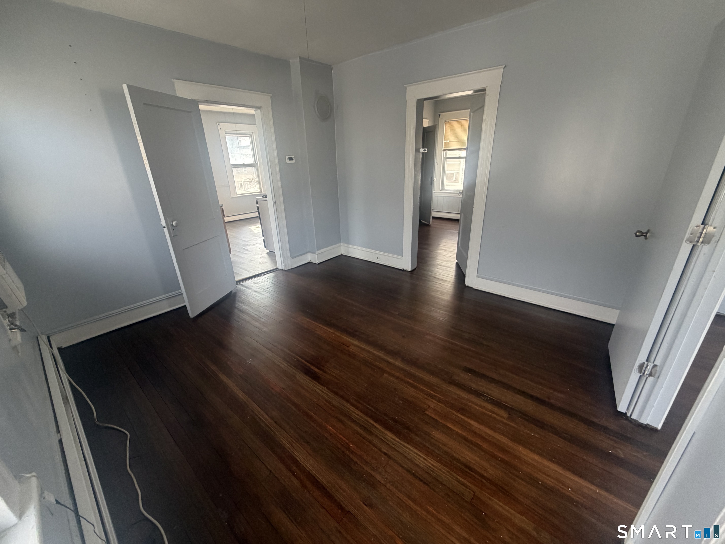 463 Logan Street, Unit 2 Bridgeport, CT 06607 - Photo 9 of 11 a view of an empty room with wooden floor and a window