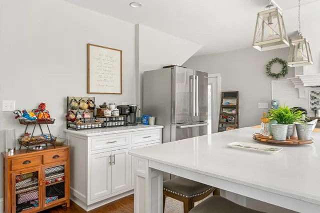 a kitchen with stainless steel appliances kitchen island granite countertop a refrigerator and a stove top oven