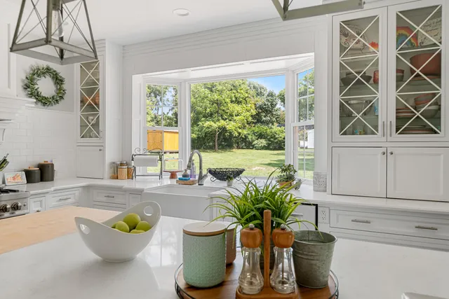 a living room with a potted plant and a large window