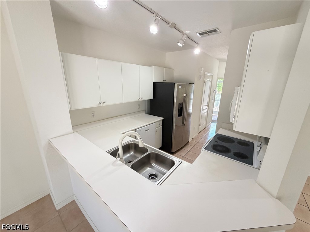 8541 Athena Court Lehigh Acres, FL 33971 - Photo 4 of 17 a kitchen with a refrigerator and a sink