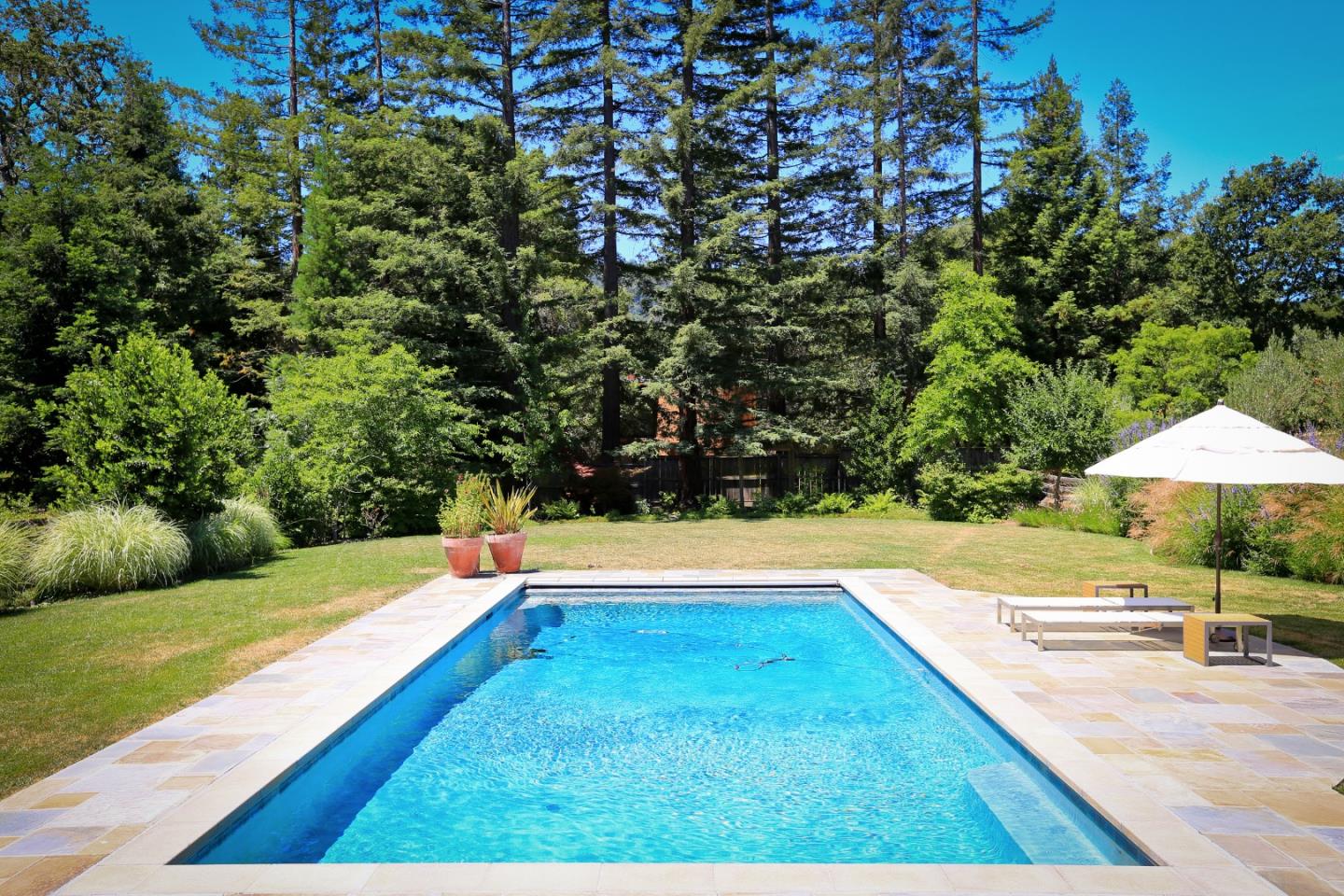 203 Miramontes Road Woodside, CA 94062 - Photo 1 of 8 a view of swimming pool with lawn chairs under an umbrella