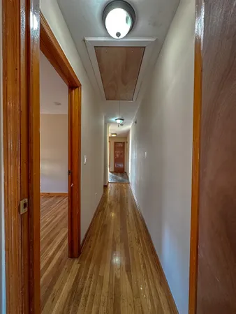a view of a hallway with wooden floor and staircase