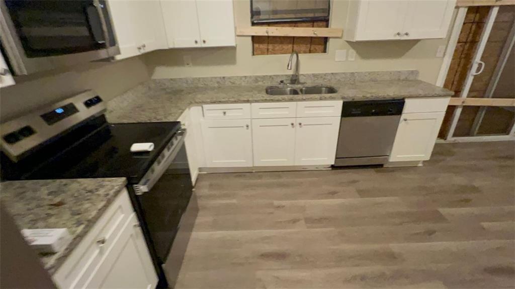 3766 Chimney Ridge Court Ellenwood, GA 30294 - Photo 2 of 9 a kitchen with granite countertop a sink stove and cabinets