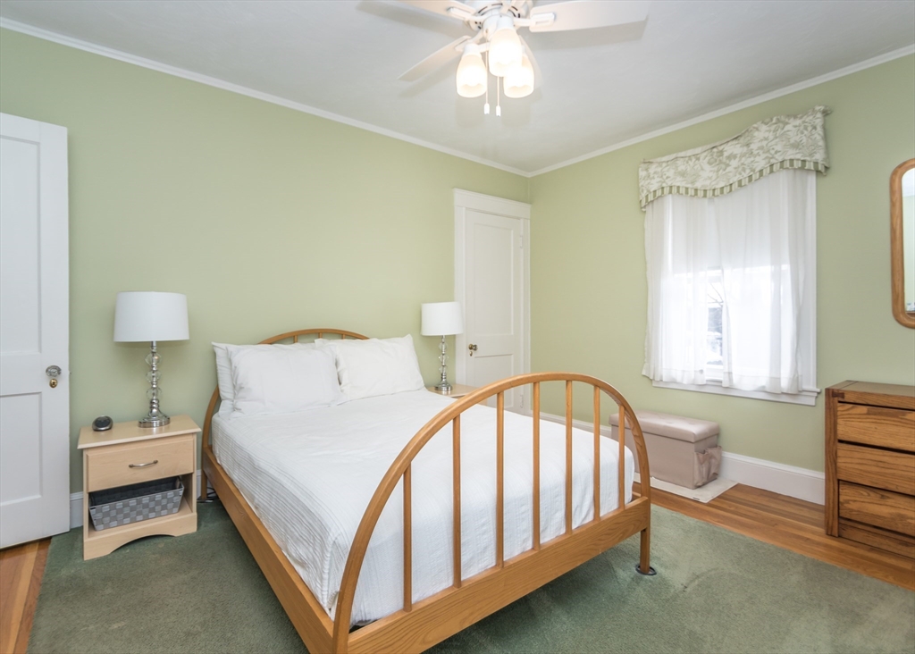 279-281 Ash Street Waltham, MA 02453 - Photo 34 of 39 a bed room with a bed and a chandelier