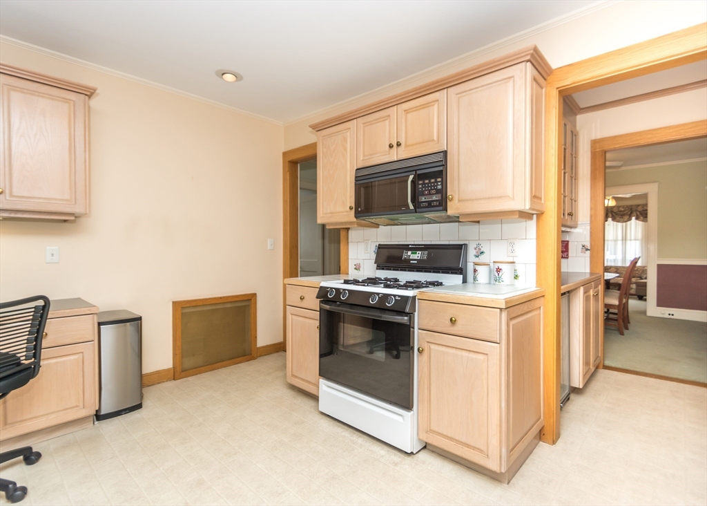 279-281 Ash Street Waltham, MA 02453 - Photo 6 of 39 a kitchen with stainless steel appliances granite countertop white cabinets a stove top oven a sink and dishwasher