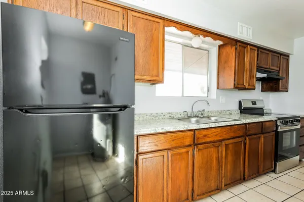 a kitchen with stainless steel appliances granite countertop a refrigerator and a sink