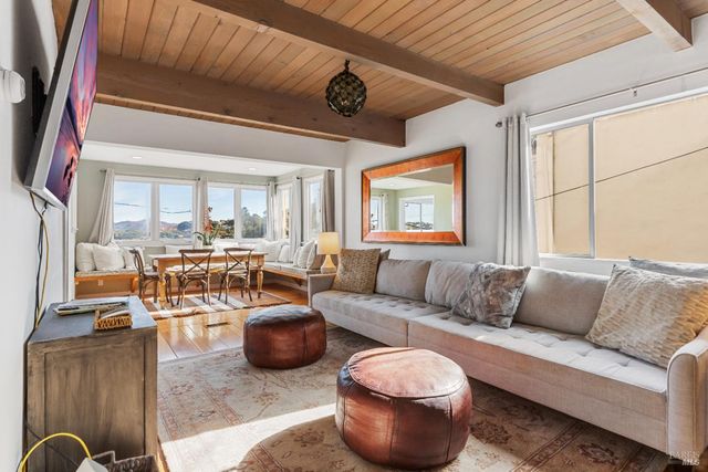 a dining room with furniture and large windows