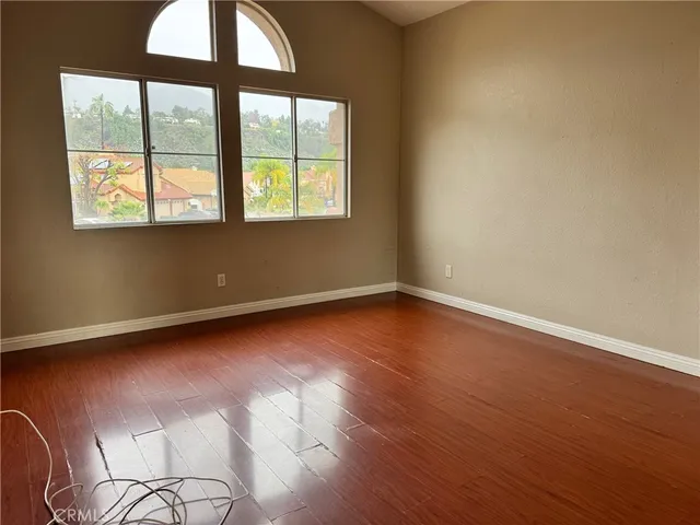 an empty room with wooden floor and a window