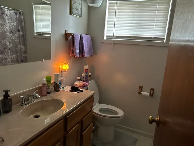 a bathroom with a sink vanity mirror and toilet