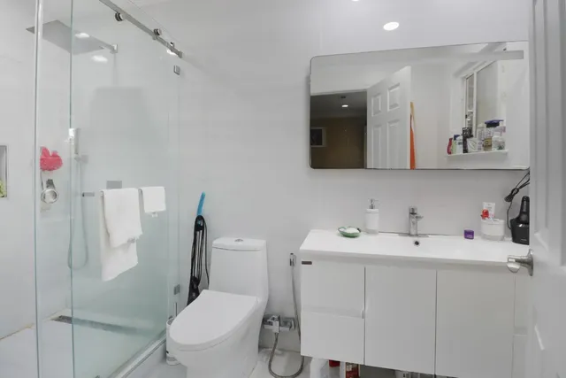 a bathroom with a sink vanity mirror and toilet