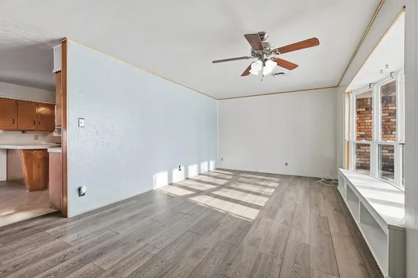 a view of a livingroom with wooden floor and a ceiling fan