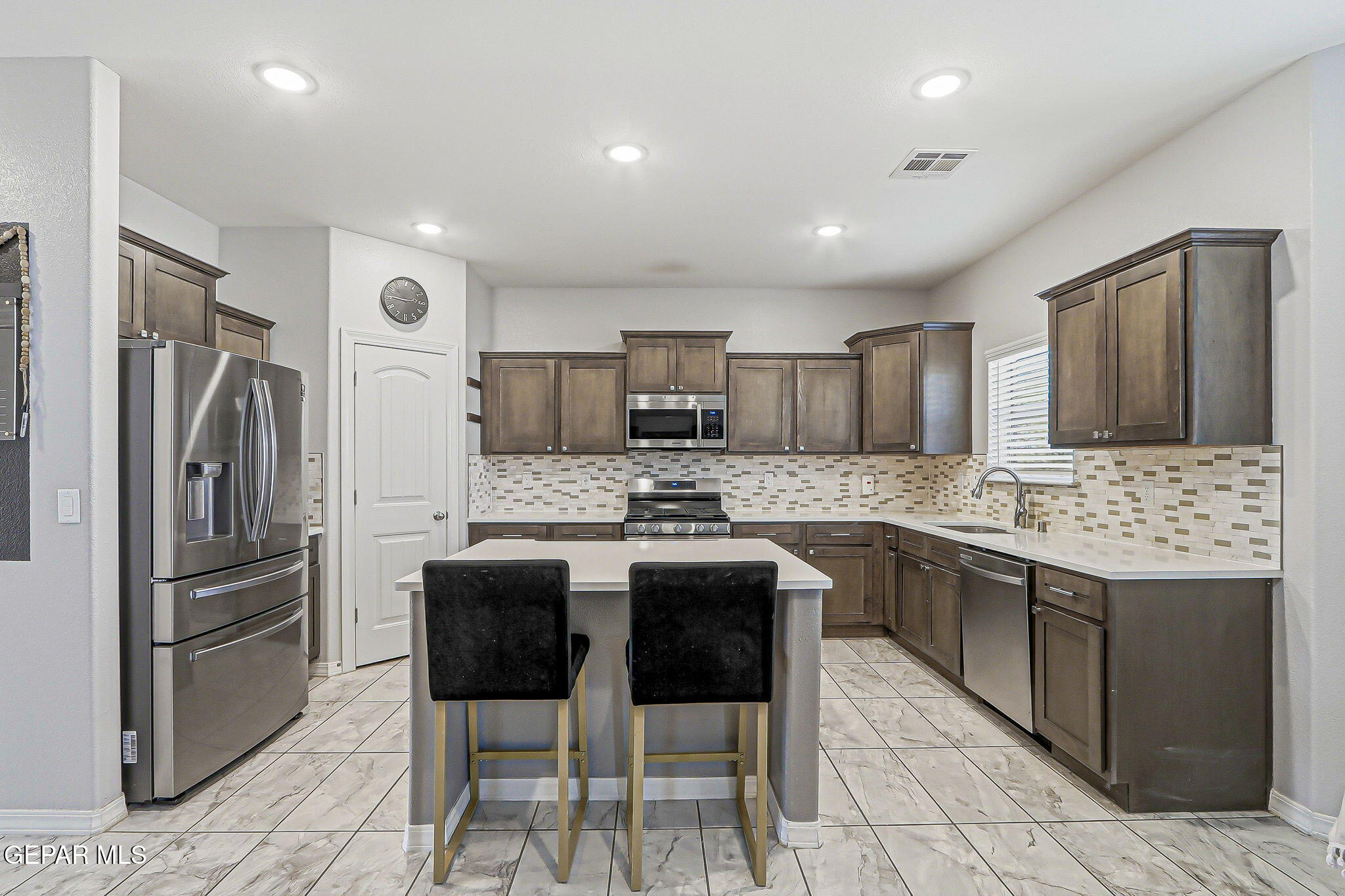 525 Issa Circle El Paso, TX 79932 - Photo 15 of 47 a kitchen with stainless steel appliances kitchen island granite countertop a refrigerator and a stove top oven
