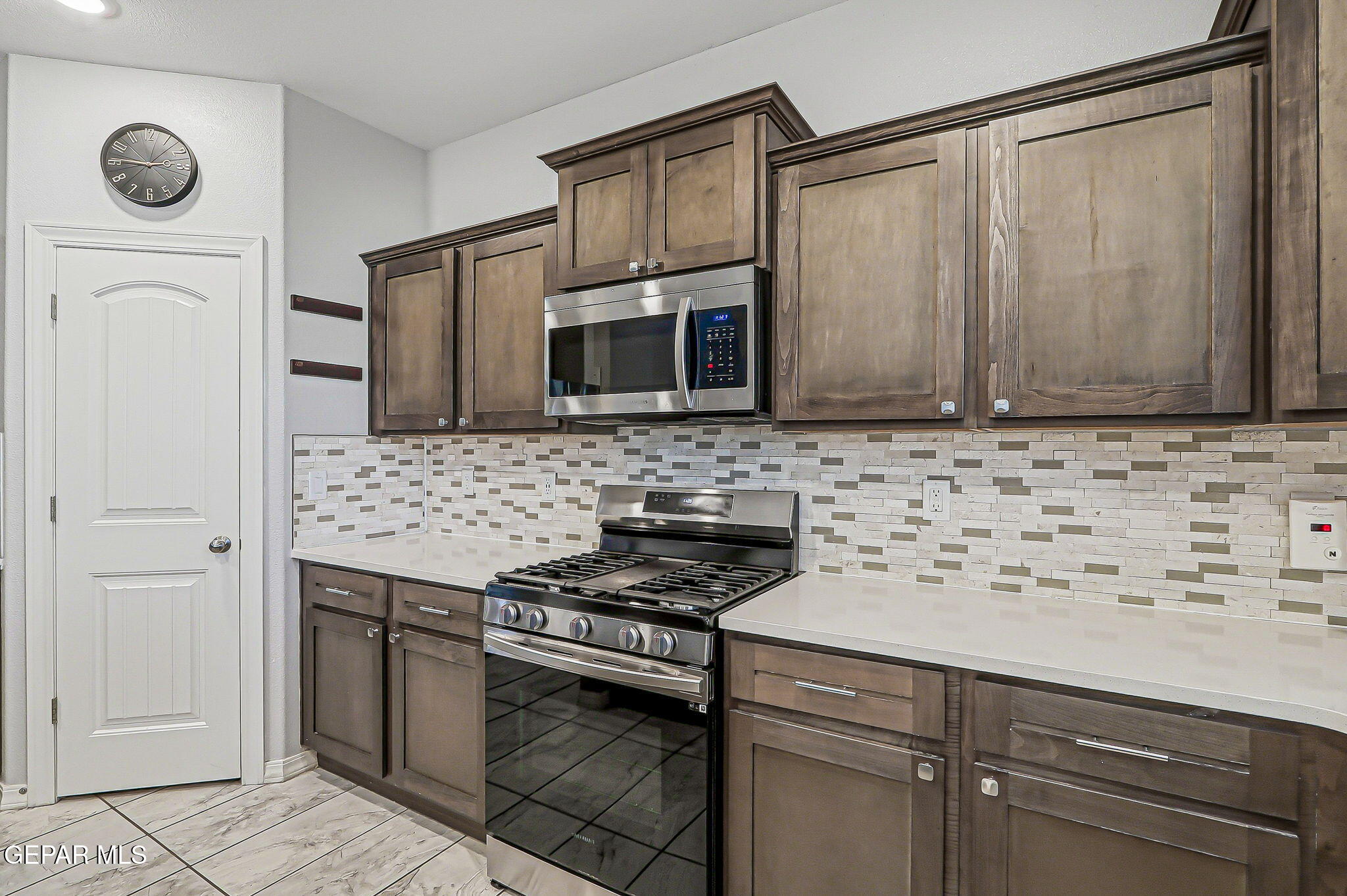 525 Issa Circle El Paso, TX 79932 - Photo 21 of 47 a kitchen with stainless steel appliances granite countertop a stove a microwave and a sink